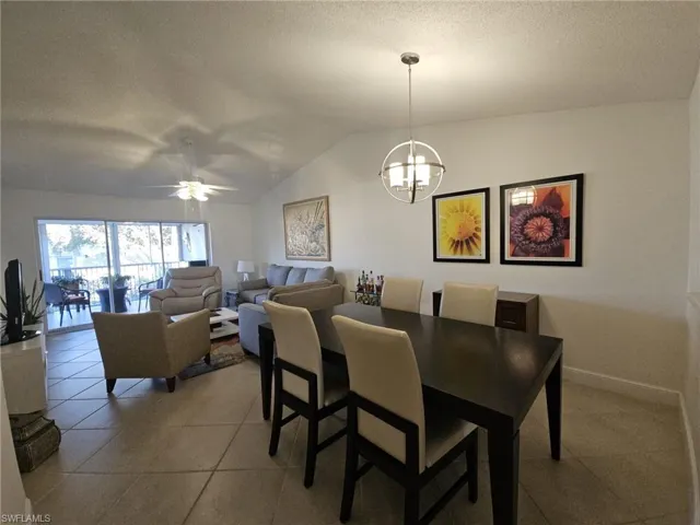 Tiled dining room featuring a ceiling fan and hanging lights