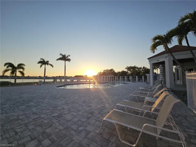Patio terrace at dusk with a patio area and a community pool