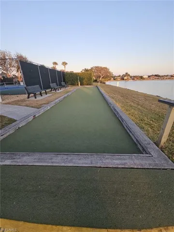 Surrounding community with a water view and a bocce ball area