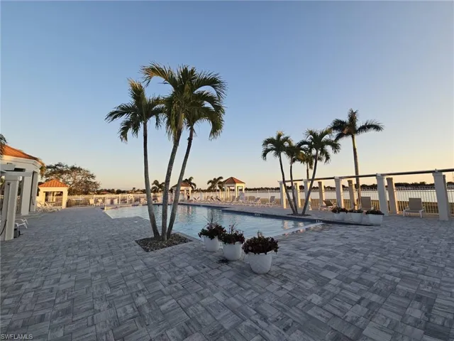Pool at dusk featuring a community pool and a patio