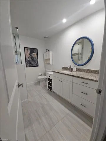 Full bath featuring vanity and a shower with door
