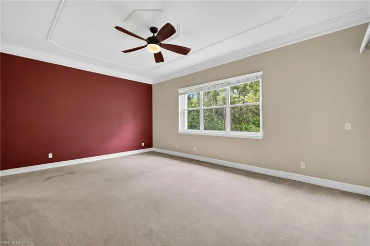 Unfurnished room featuring ornamental molding, a ceiling fan, and carpet flooring
