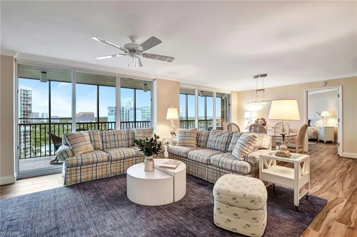 Living room with ceiling fan, crown molding, and tile flooring