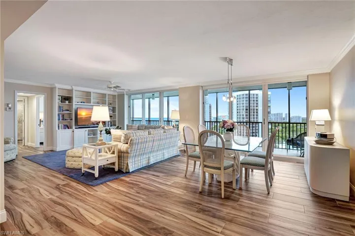 Living room open to dining room featuring ceramic tile flooring and crown molding. Sliders to lanai for gorgeous view.