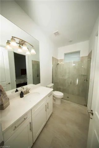 2nd Bathroom featuring vanity, toilet, an enclosed shower, and wood-type flooring