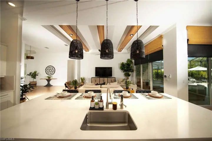 Kitchen featuring pendant lighting, beamed ceiling, hardwood / wood-style floors, and sink