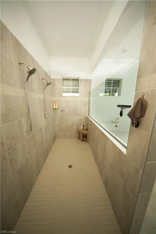 View of primary walk-in shower with multiple shower heads
