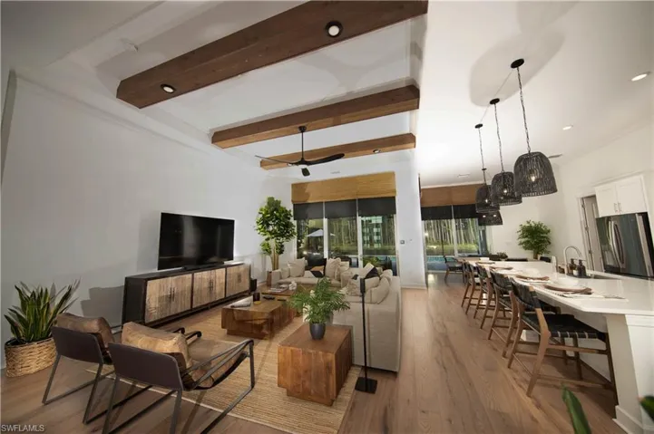 Living room featuring light hardwood / wood-style flooring, beam ceiling, and ceiling fan