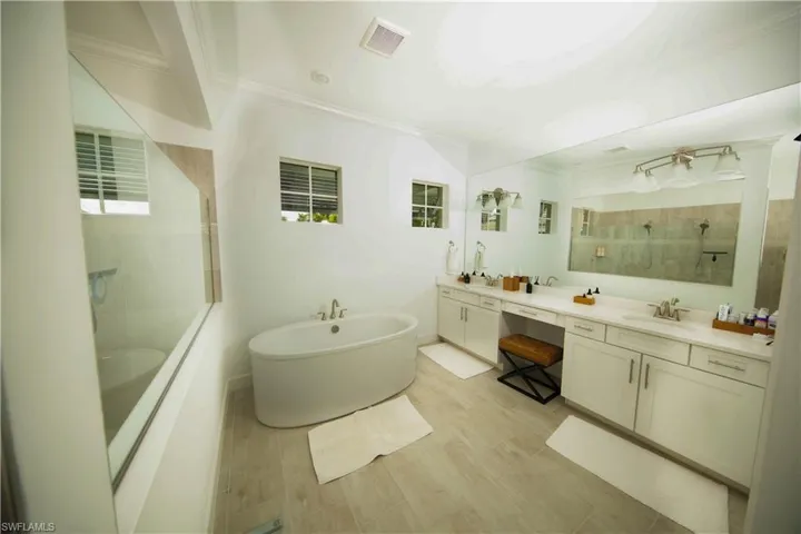 Primary Bathroom featuring vanity, a healthy amount of sunlight, wood-type flooring, and shower with separate bathtub