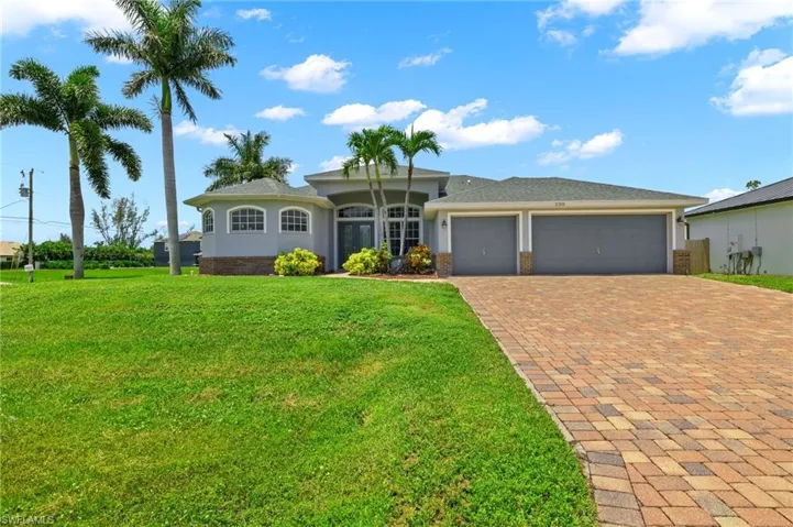 Ranch-style home featuring a garage and a front lawn