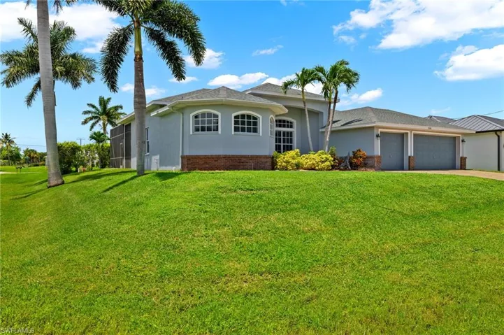 View of front facade featuring a garage and a front lawn