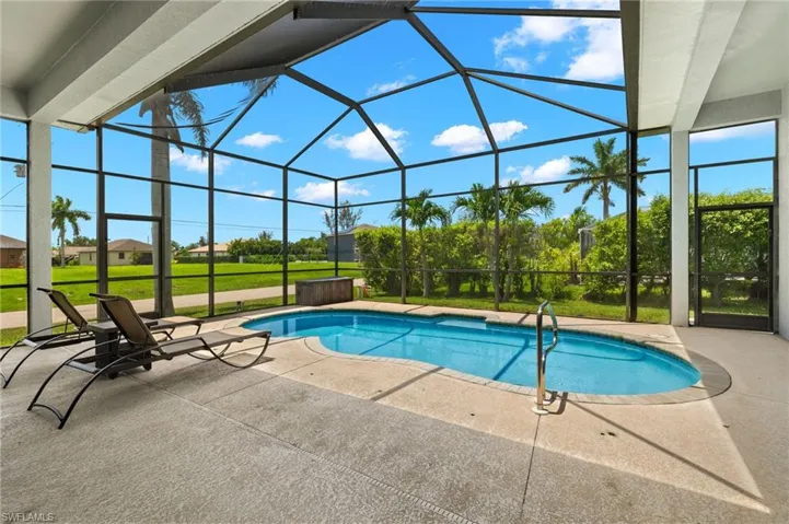 View of swimming pool featuring a patio and a lanai