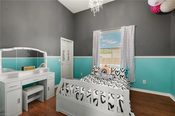 Bedroom with an inviting chandelier and wood-type flooring