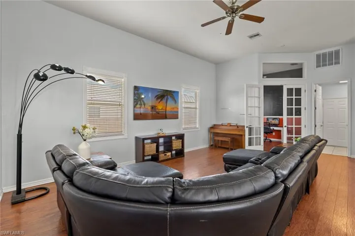 Living room featuring wood-type flooring, ceiling fan, french doors, and lofted ceiling