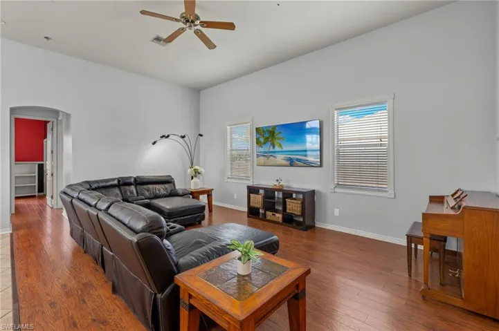 Living room featuring ceiling fan, wood-type flooring, and a wealth of natural light