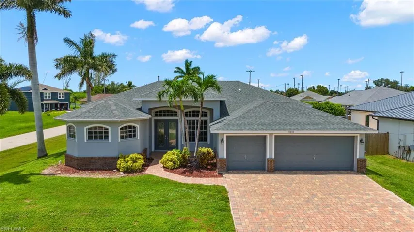 Ranch-style house featuring a garage and a front lawn