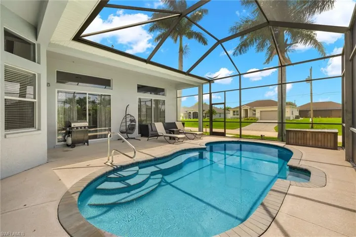 View of swimming pool featuring a patio area, a lanai, grilling area, and a yard