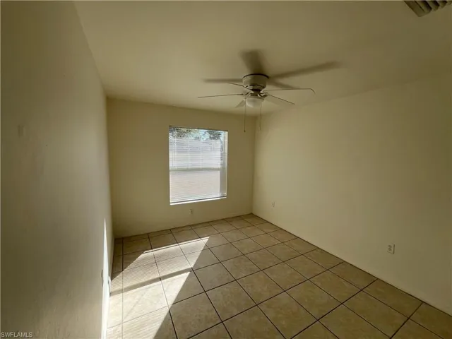 Unfurnished room featuring light tile patterned floors and a ceiling fan