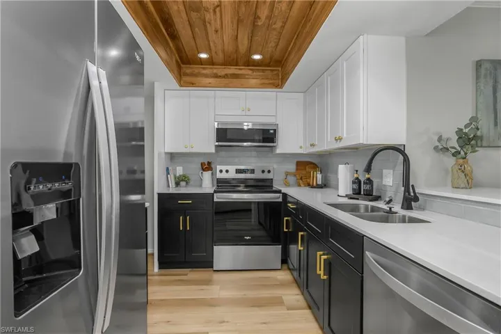 Kitchen featuring two tone shaker style cabinetry, stainless steel appliances, light quartz counters, and cypress wood ceiling, new stainless appliances.