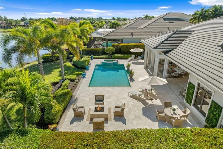 View of swimming pool featuring a patio area, a pool with connected hot tub, outdoor dining area, and an outdoor living space with a fire pit
