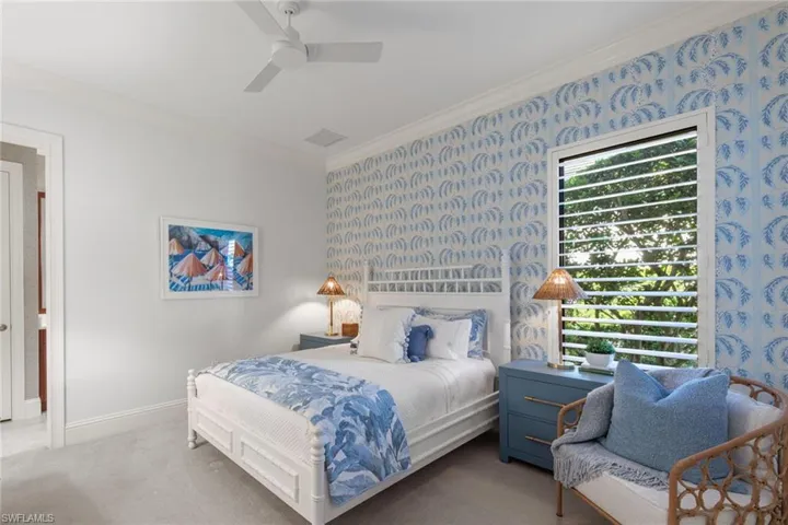 Bedroom featuring crown molding, wallpapered walls, a ceiling fan, and carpet floors