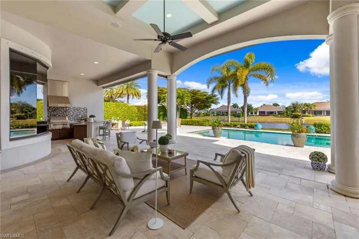 View of patio / terrace featuring area for grilling, ceiling fan, an outdoor pool, an outdoor hangout area, and a residential view