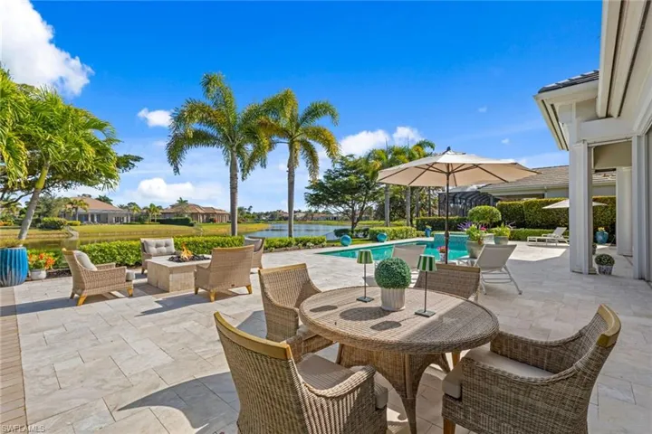 View of patio / terrace with an outdoor fire pit, an outdoor pool, a water view, and outdoor dining space