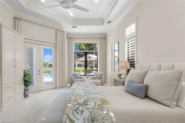 Carpeted bedroom featuring a tray ceiling, french doors, ceiling fan, recessed lighting, and access to outside