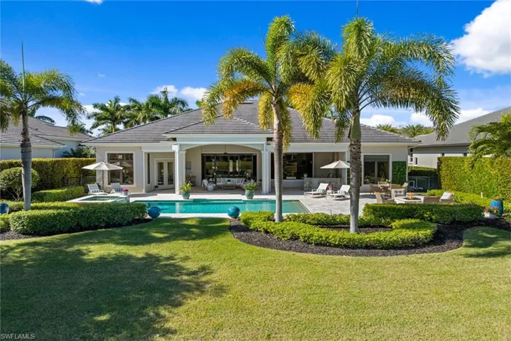 Rear view of house with a patio area, french doors, a pool with connected hot tub, and stucco siding