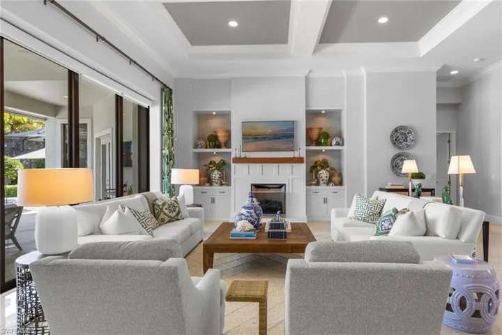 Living area featuring beamed ceiling, a fireplace, recessed lighting, and crown molding