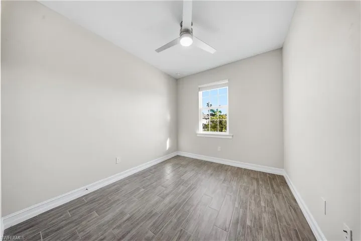 Unfurnished room with wood tiled floors and a ceiling fan