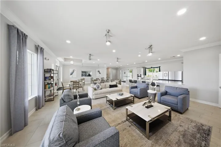 Living area featuring ornamental molding and recessed lighting