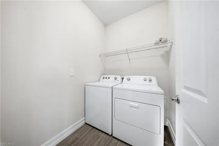 Laundry area with washer and dryer and wood finish floors