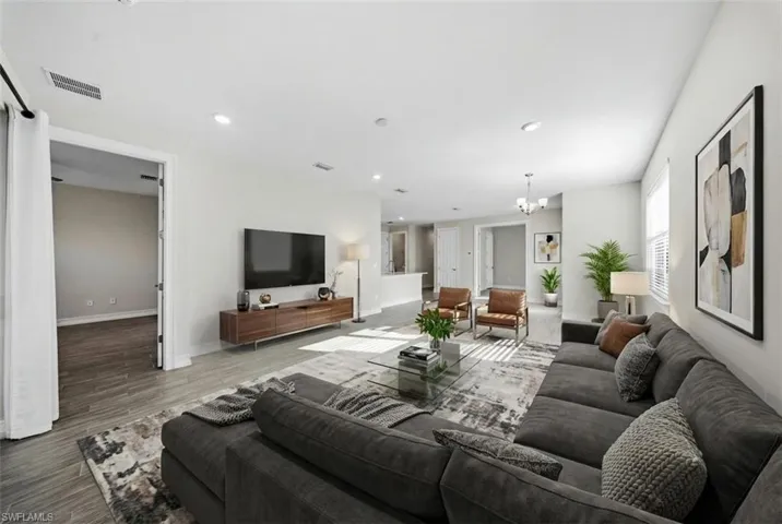 Living room featuring hanging lights and wood finished floors