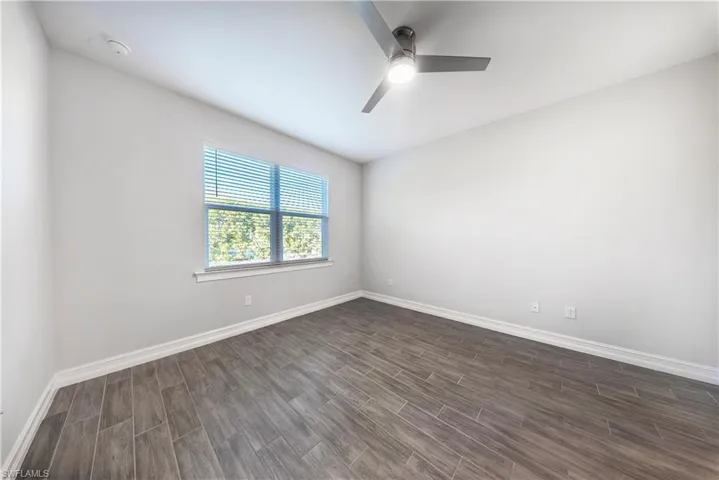 Unfurnished room featuring wood finish floors and a ceiling fan