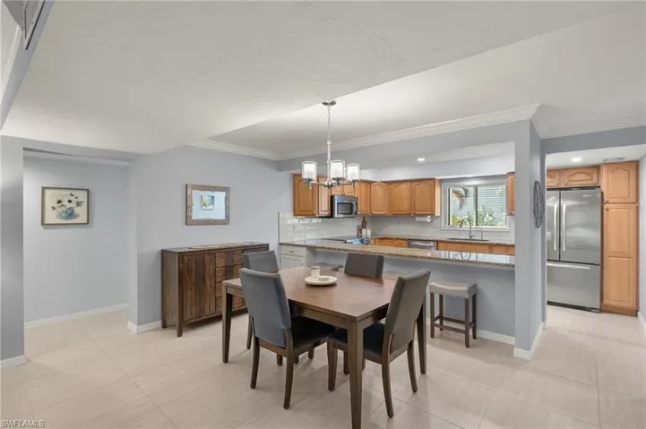 Dining room featuring ornamental molding, an inviting chandelier, and baseboards