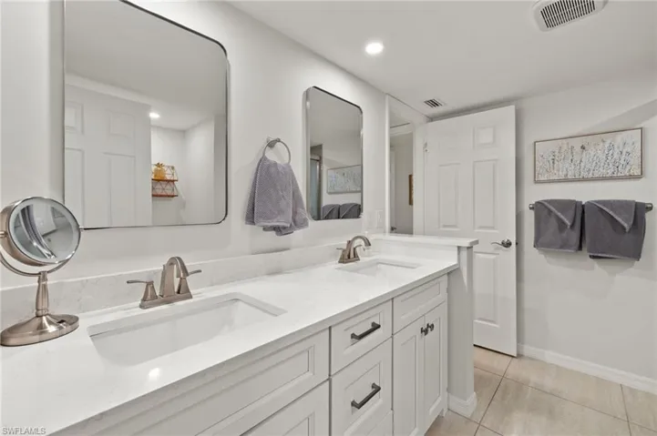 Full bath with tile patterned flooring, a sink, double vanity, and visible vents