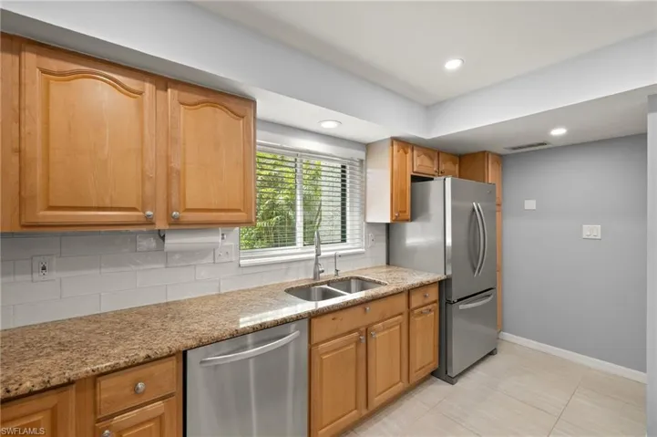 Kitchen with a sink, tasteful backsplash, visible vents, baseboards, and appliances with stainless steel finishes