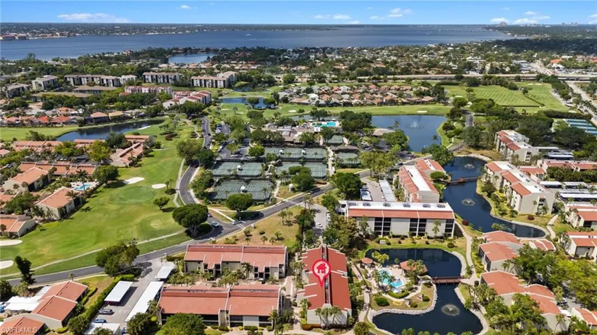 Drone / aerial view with golf course view, a water view, and a residential view