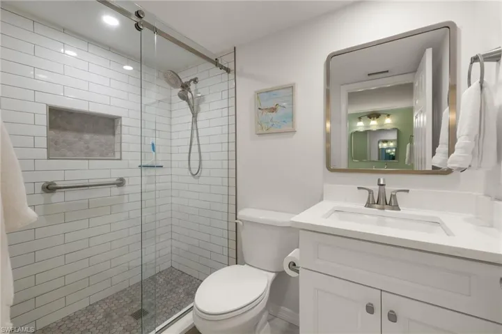 Bathroom featuring toilet, a stall shower, and vanity