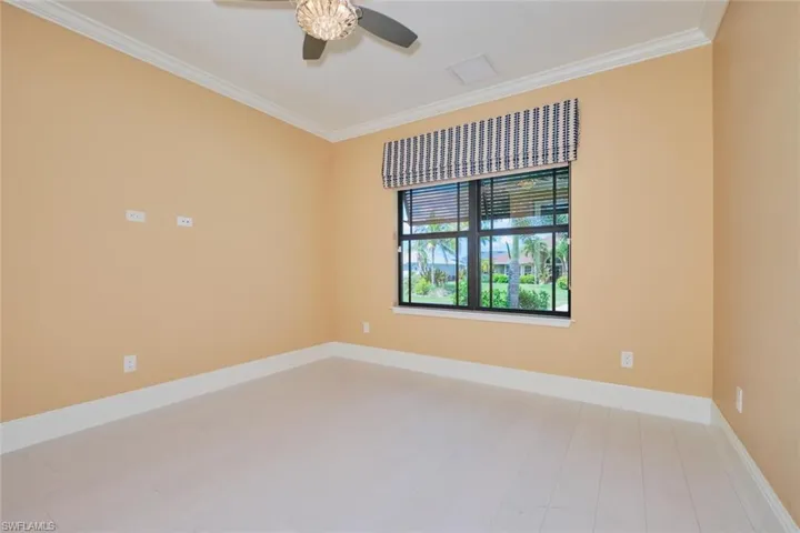 Spare room with crown molding, a ceiling fan, and wood finished floors