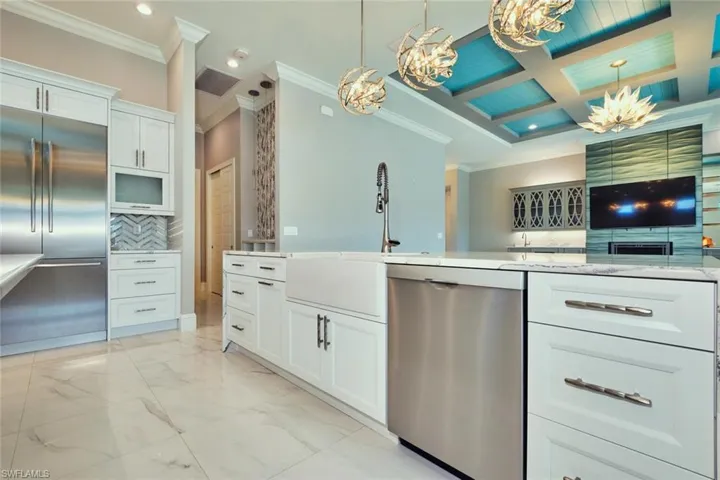 Kitchen featuring stainless steel appliances, a chandelier, ornamental molding, recessed lighting, and white cabinets