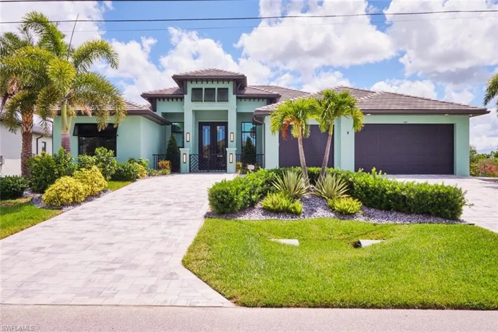 Mediterranean / spanish-style house with decorative driveway, stucco siding, a front yard, and an attached garage
