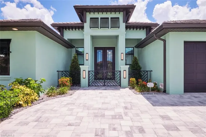 View of exterior entry with french doors, stucco siding, a tile roof, and a gate
