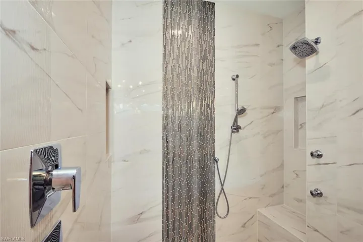 Full bath with a marble finish shower