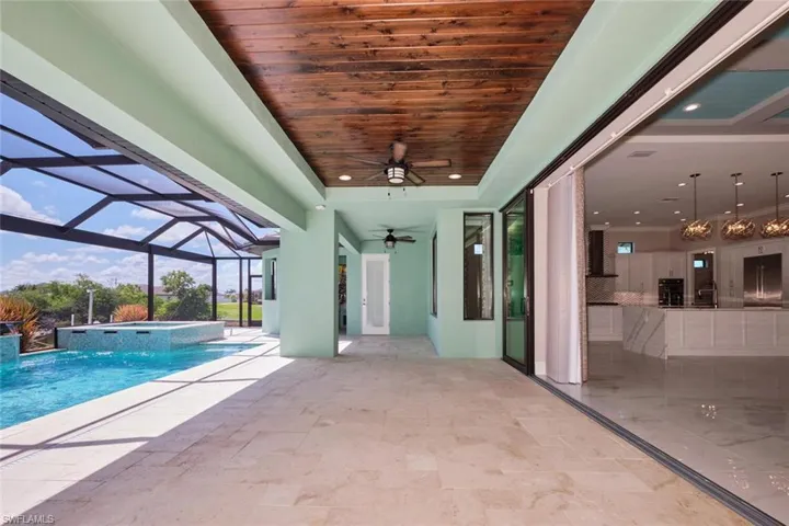 View of pool with a ceiling fan, a patio, a pool with connected hot tub, and a lanai