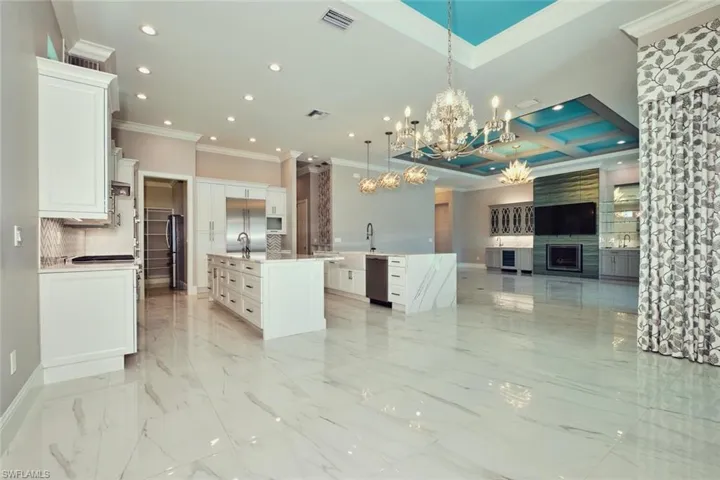 Kitchen with a large island, crown molding, open floor plan, recessed lighting, and a chandelier