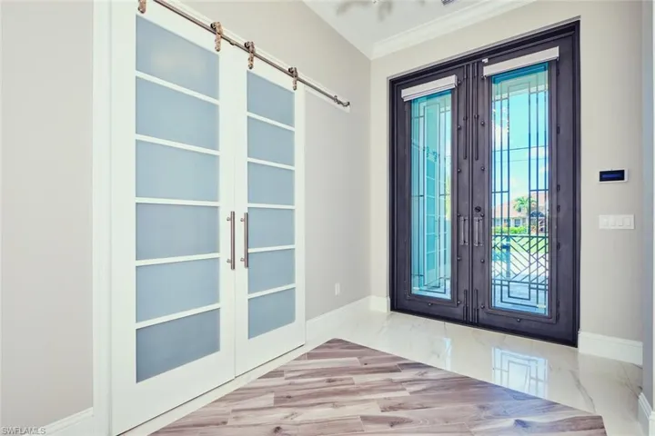 Foyer featuring french doors, crown molding, and marble finish flooring