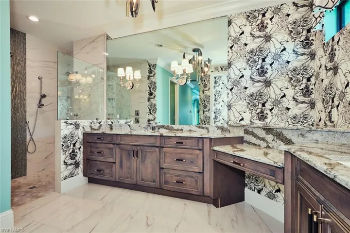 Bathroom featuring a marble finish shower, a chandelier, marble finish flooring, vanity, and recessed lighting