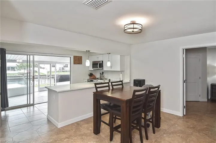 Dining area with light tile patterned floors, visible vents, and baseboards